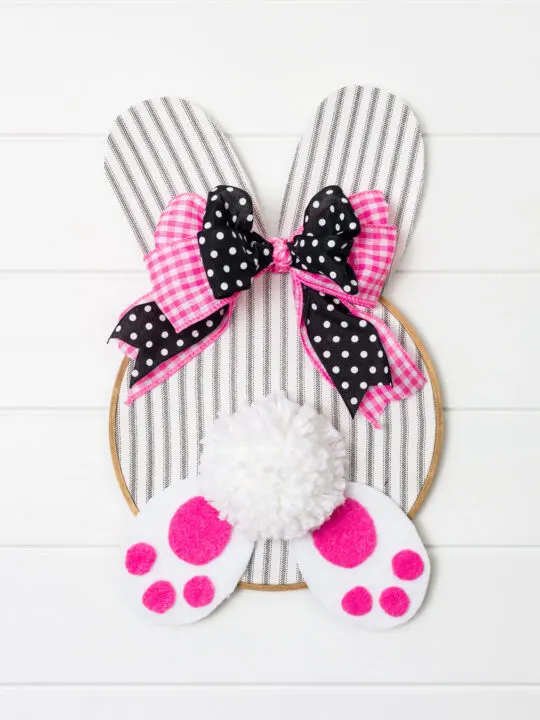 Embroidery Hoop Bunny with black, white and hot pink bow hanging on a white wall 