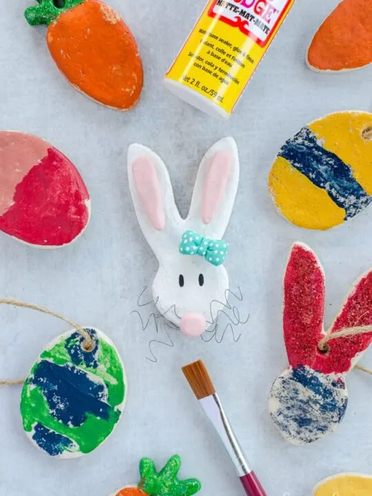 Salt dough easter decorations painted bunnies, eggs, and carrots on a table 
