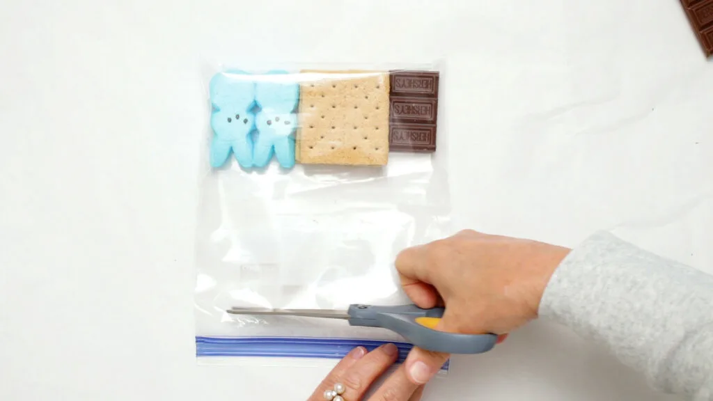 Using scissors to cut the top of the plastic bag 