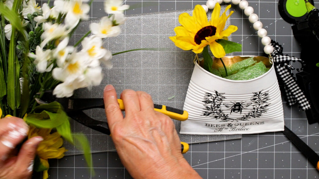 Filling the planter with faux flowers using the foam to hold them in place