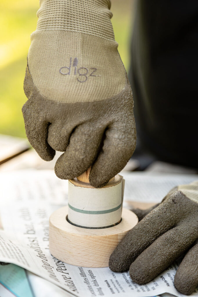 Pushing down the wooden pot maker and turning it to secure the bottom