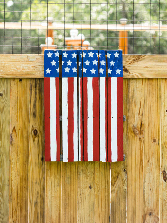Handmade pallet American Flag hanging on the wooden garden gate