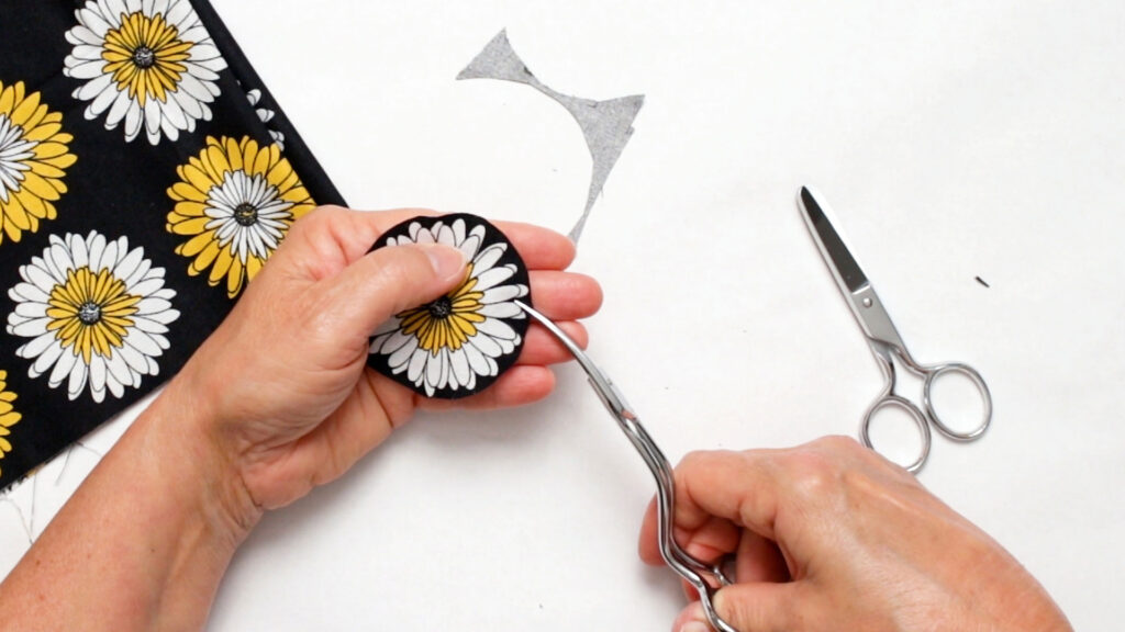 Fussing cutting around the fabric flowers with curved scissors