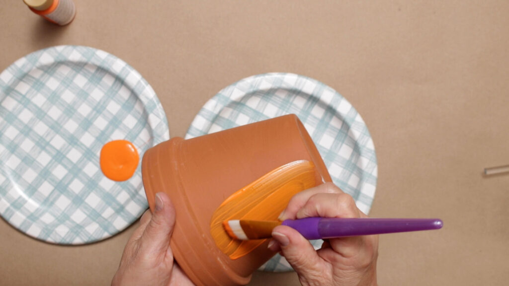 Painting the clay pot orange