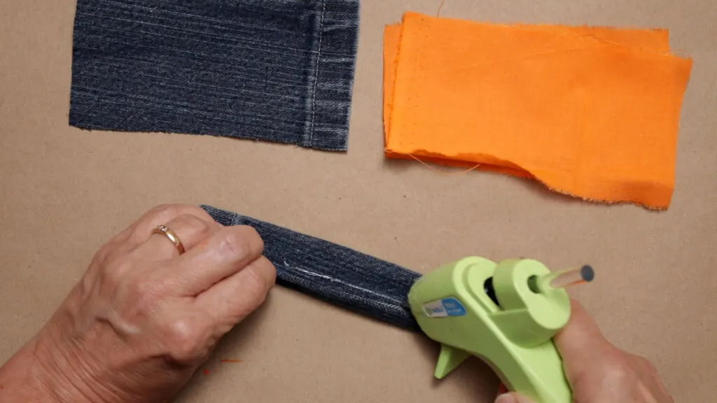 Gluing the jean fabric leg over to form a tube shape