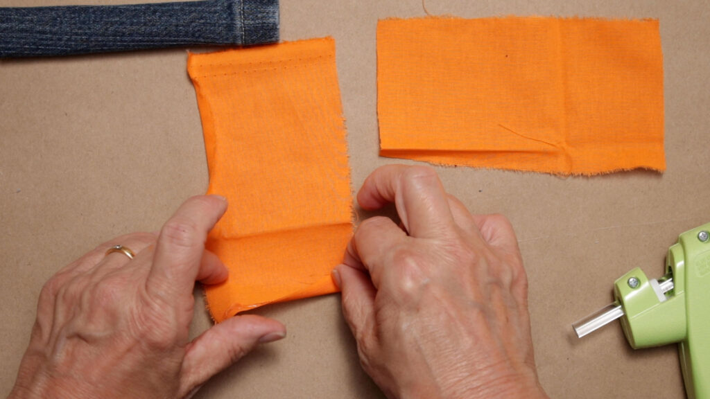 Folding over one short edge of the orange arm fabric