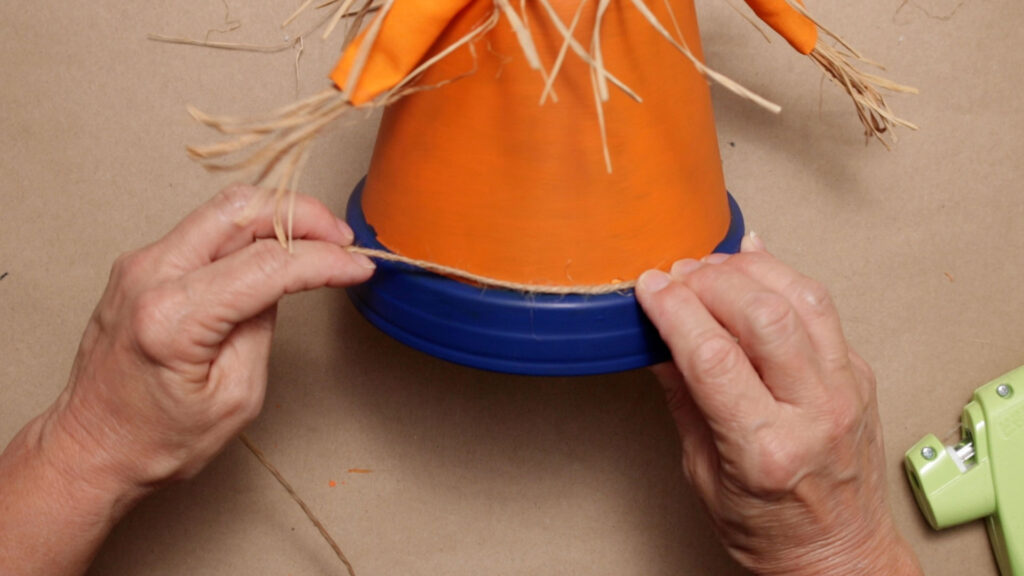 Glue on twine belt around the blue rim of the pot