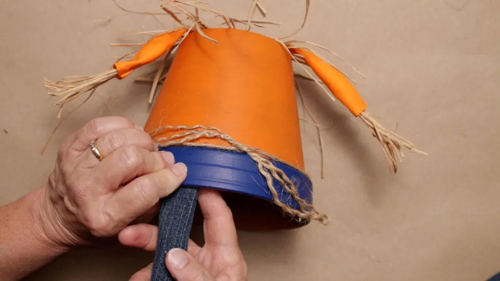 Attach the jean legs to the inside of the bottom pot's rim with glue