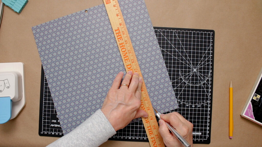 Cutting craft paper with a ruler and craft knife