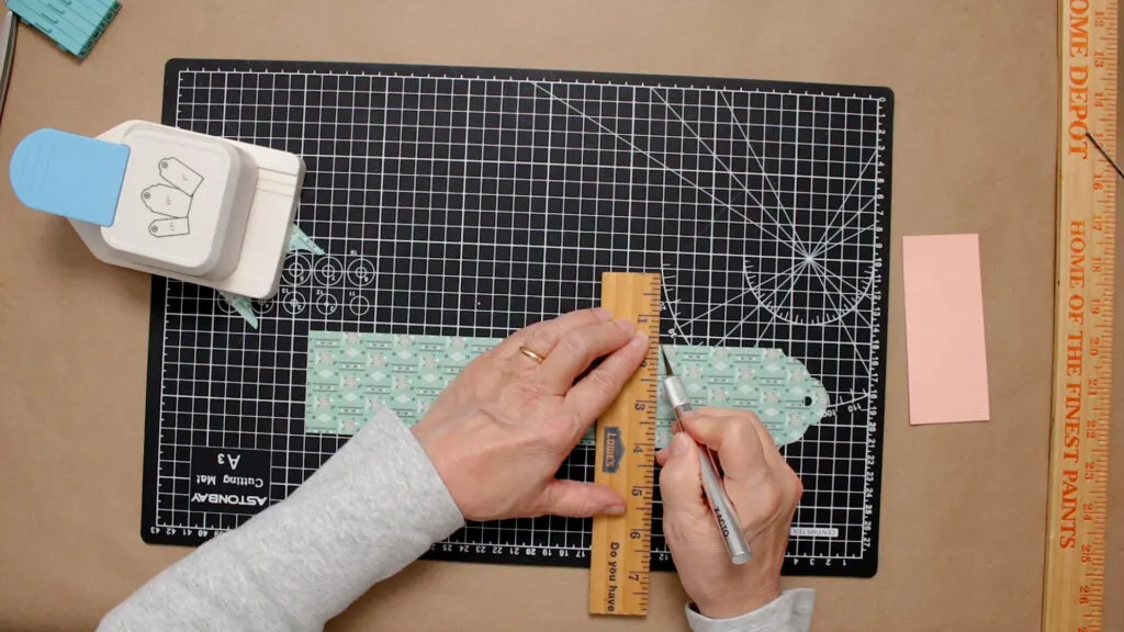 Trimming the length of the tag with a ruler and craft knife