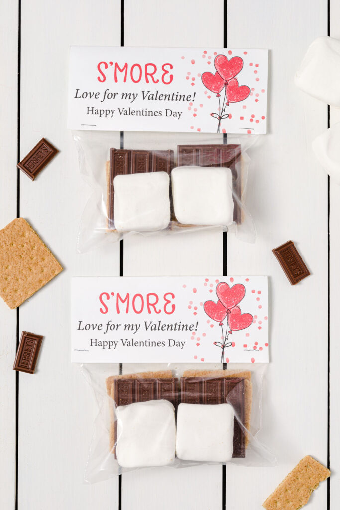 Smore kits with marshmallows, graham crackers, and chocolate bars inside a sandwich baggie with a printable topper.  