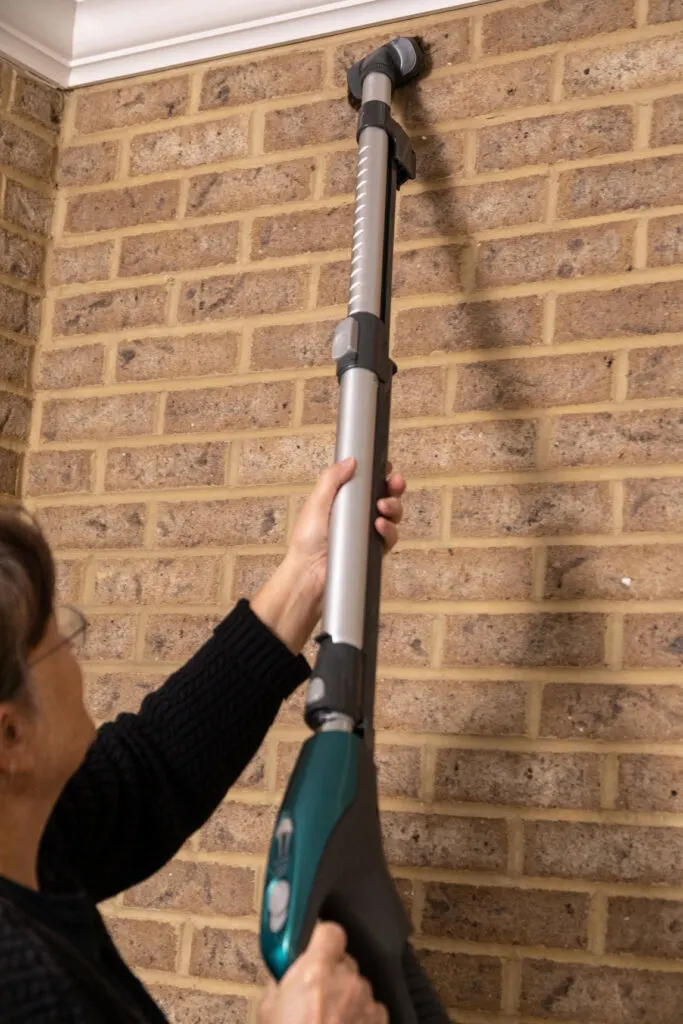 Lady vacuuming brick fireplace 