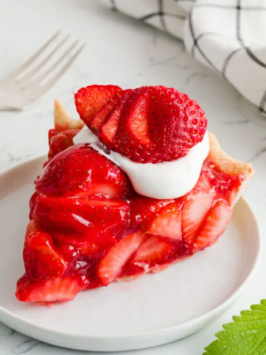 Slice of Strawberry Pie with Kool whip and a strawberry on top