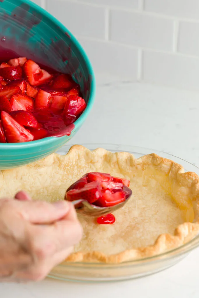 Putting the strawberries into the pie crust