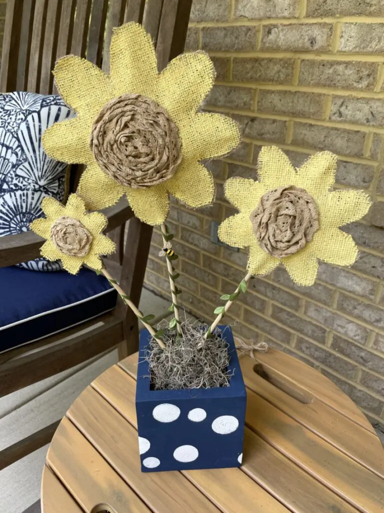 Fabric flowers in a wood block on a table on the porch