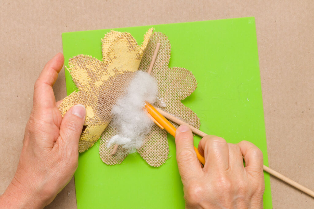 Using a pencil to help stuff the flower petals 