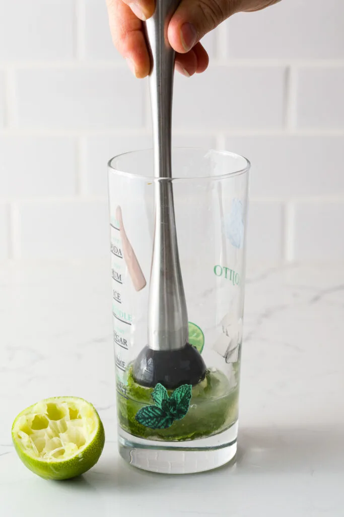 Muddling mint, simple syrup, and lime juice