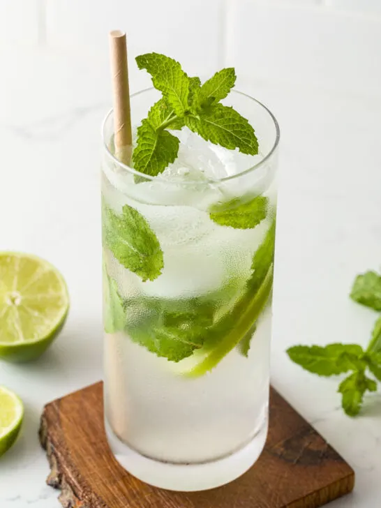 Mojito on a wooden coaster with a paper straw