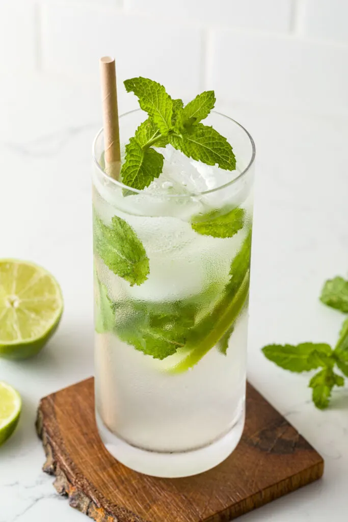 Mojito on a wooden coaster with a paper straw