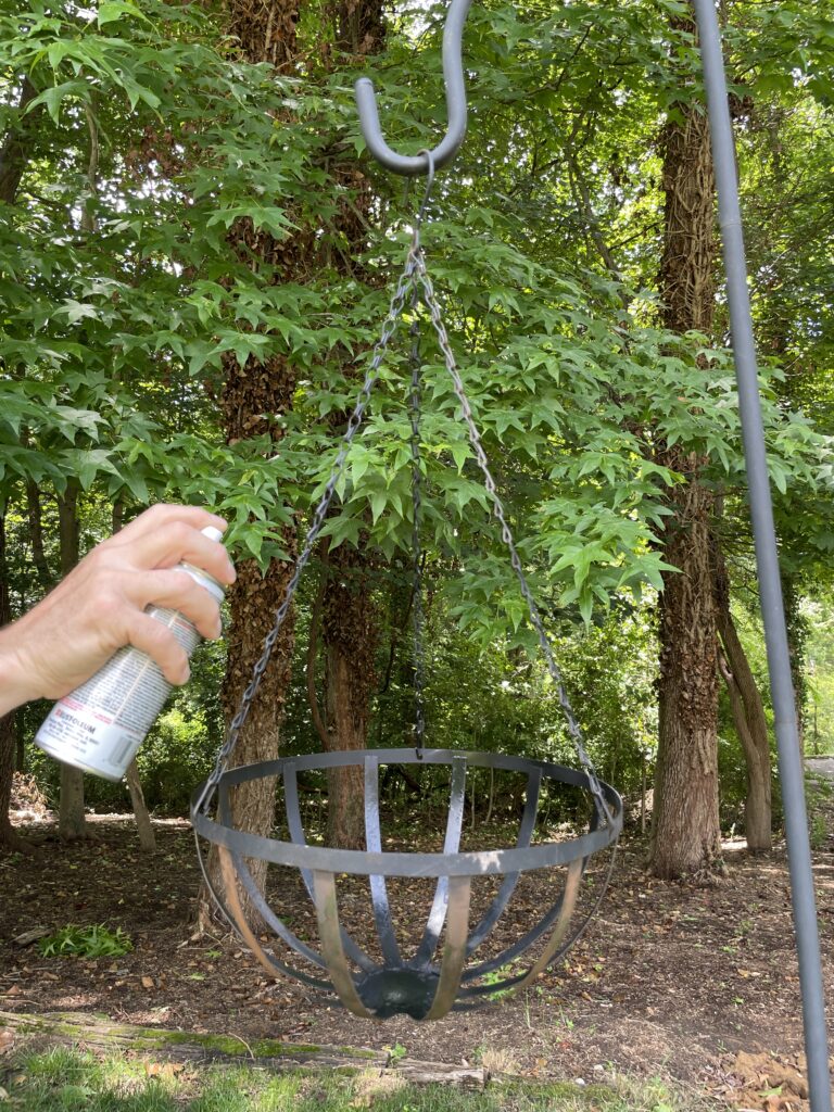 Spray painting a Basket hanging on a hook in the yard