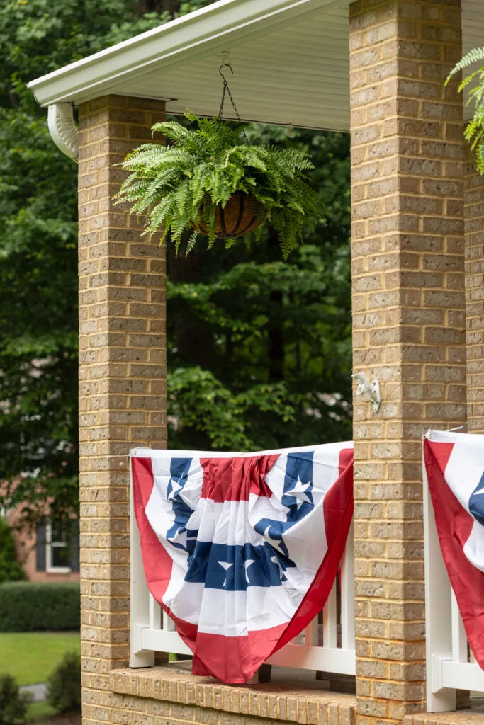 Baskets hanging from a porch with 4th of July banners