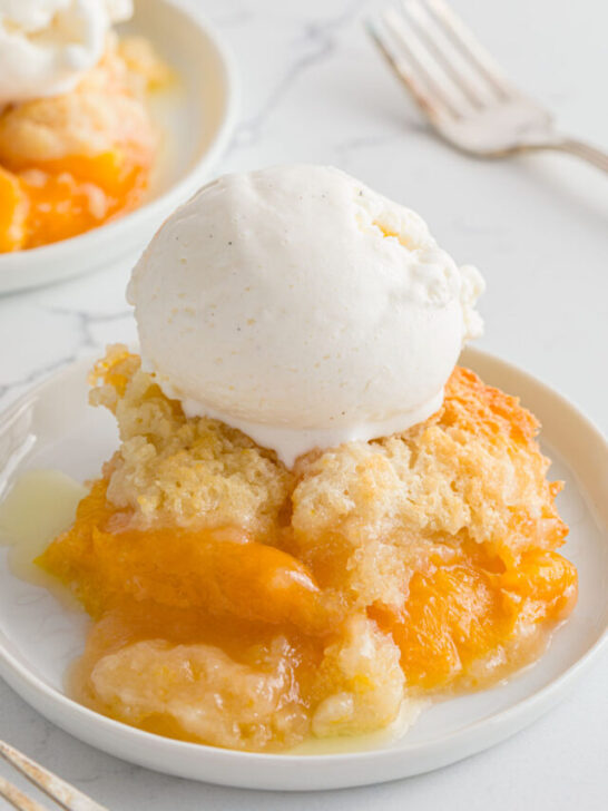 two plates with peach cobbler with ice cream