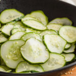 Sunomono Cucumber Salad in a black bowl with chop sticks