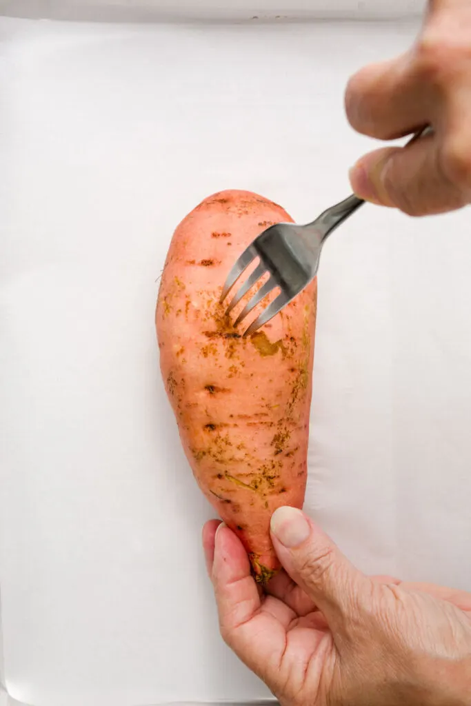 Poking holes in the sweet potato with a fork