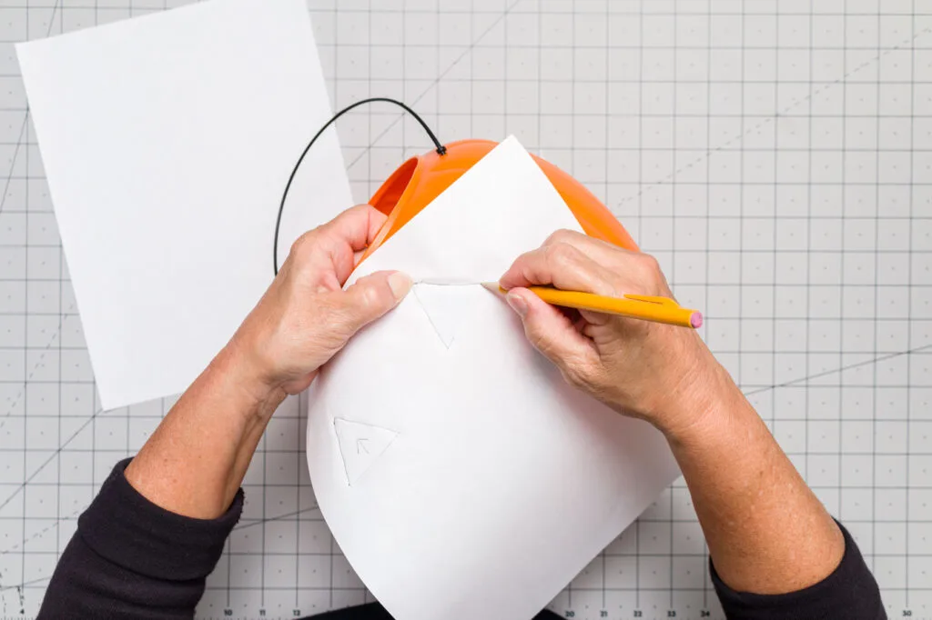 Tracing the jack-o-lantern face design on a piece of paper