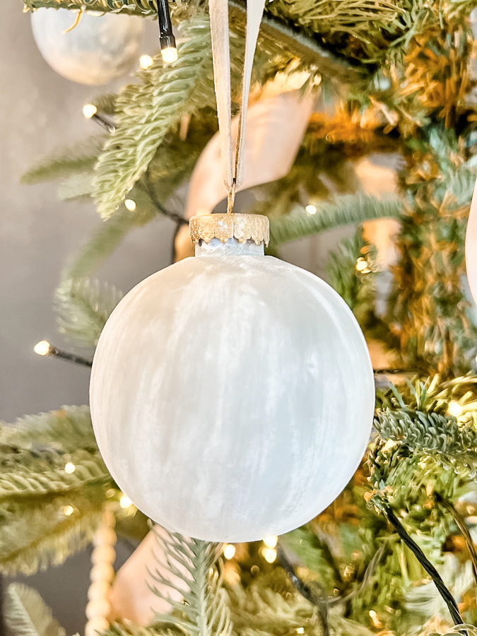 White matte textured ornament hanging in a tree