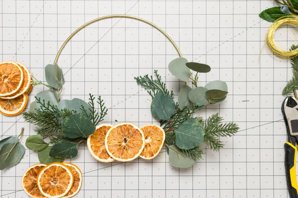 Orange slices placed on the wreath to plan the final placement