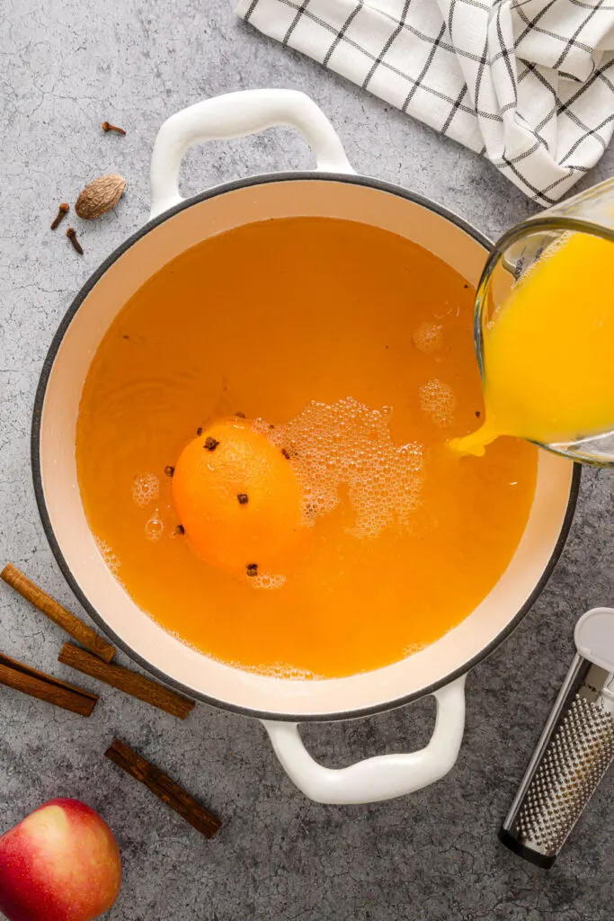 Adding fresh orange juice to the pot