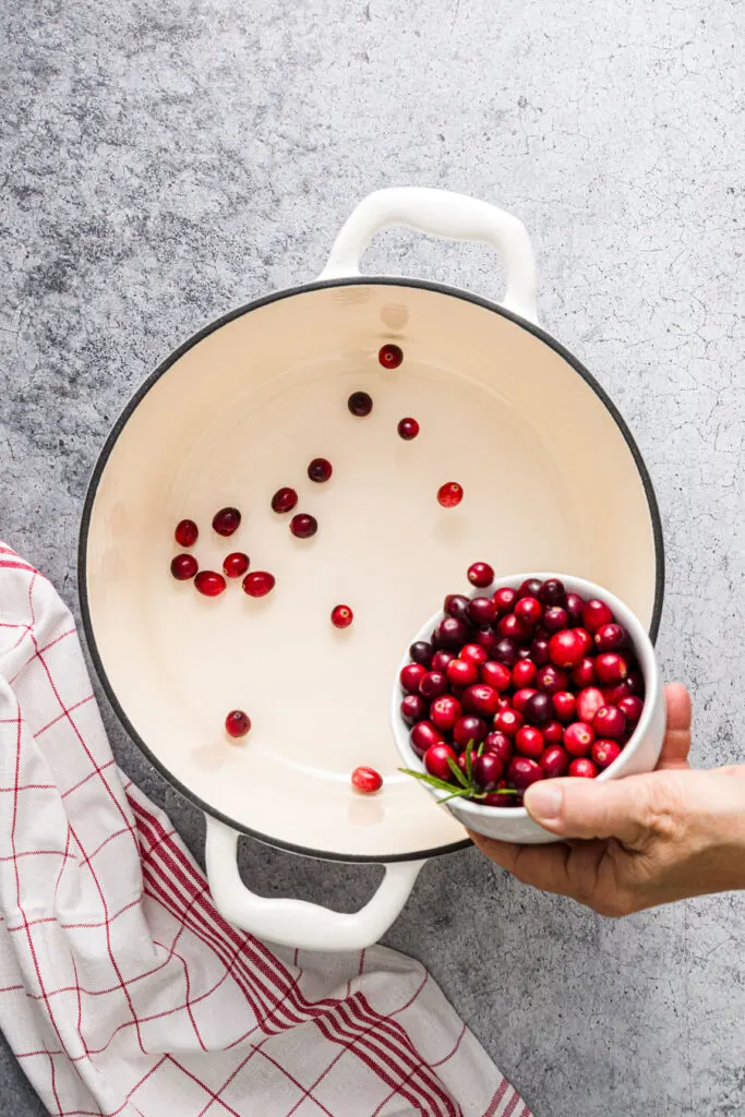 Adding fresh cranberries to large pot