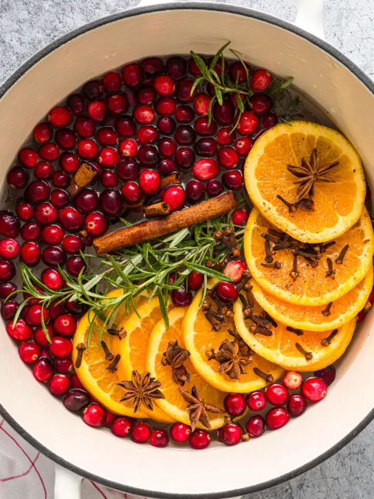 Dutch oven filled with fresh fruit, herbs, spices, and water