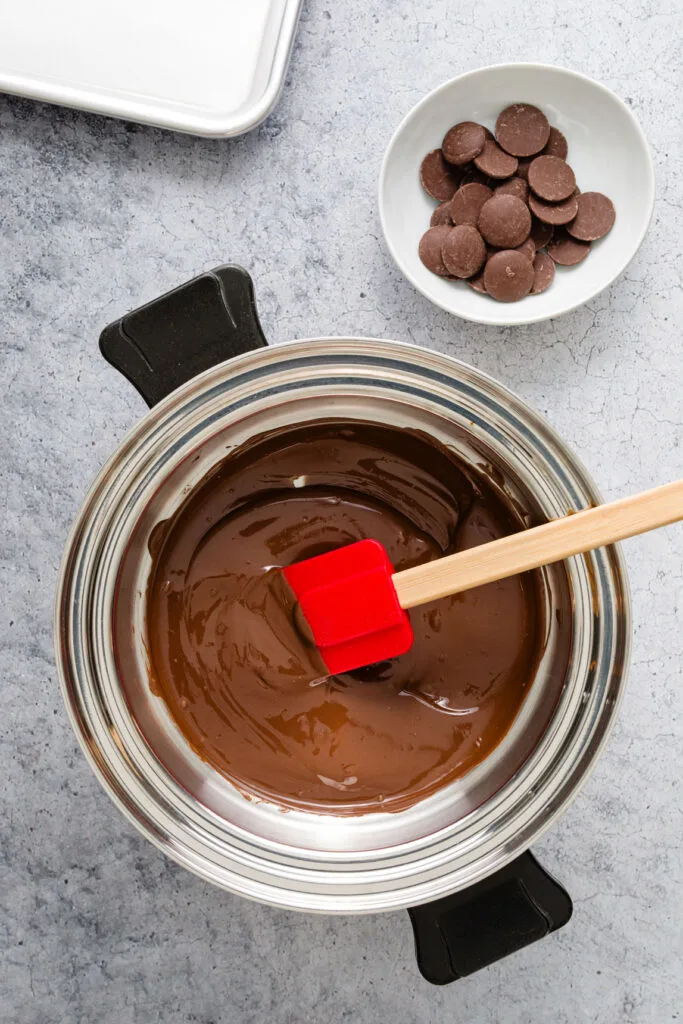 Melted chocolate next to unmelted chocolate in a bowl