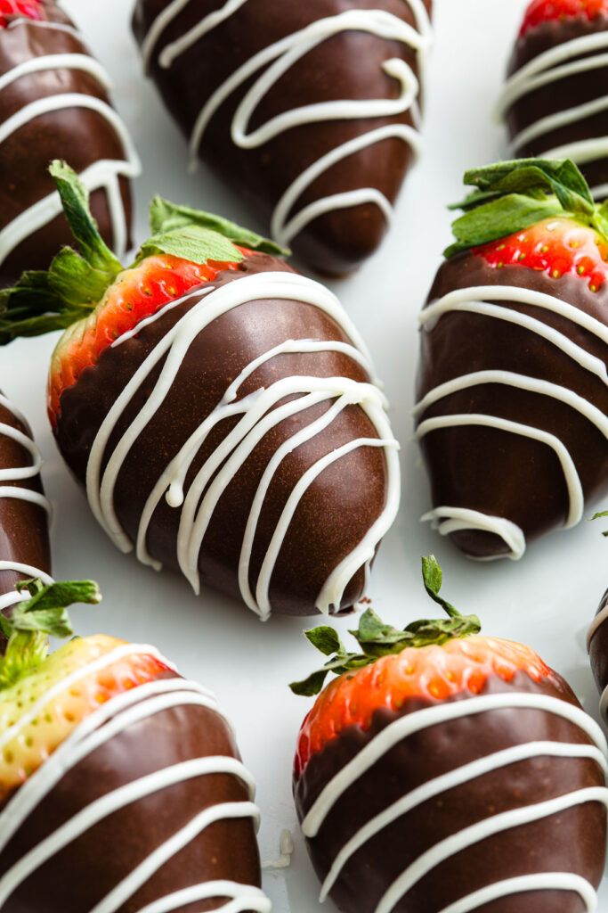 Dark chocolate covered strawberries with stripes of while chocolate