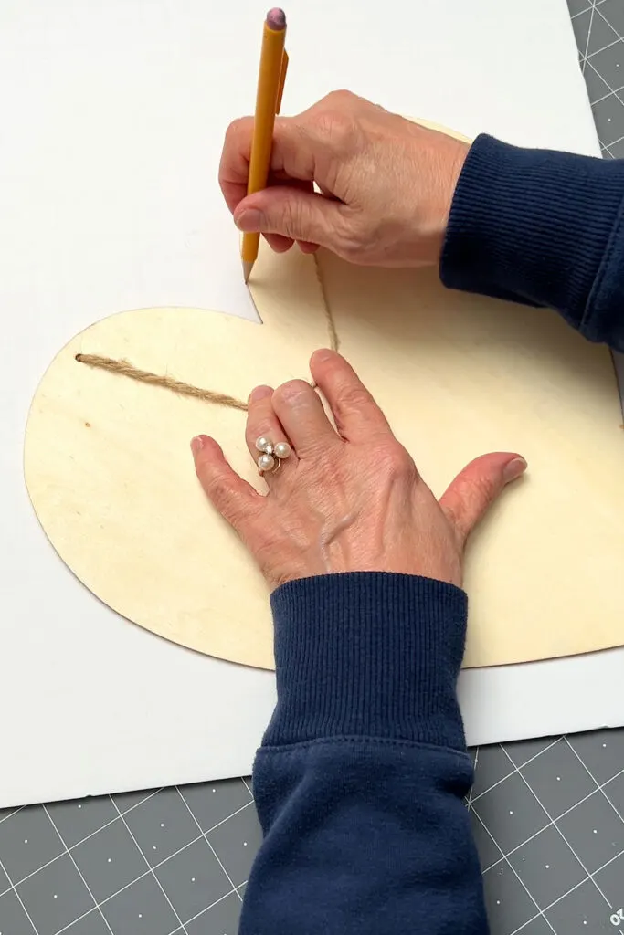 Tracing around a wooden heart on foam board