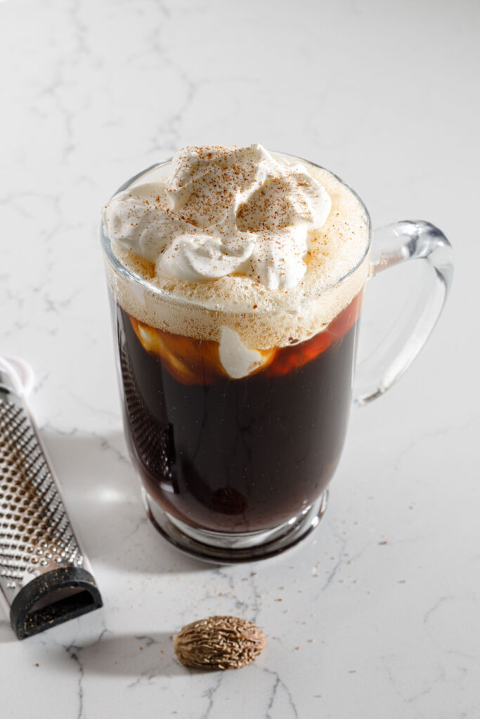 Garnishing Irish coffee with nutmeg