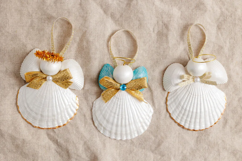 three shell angel ornaments on a cloth