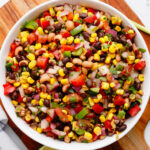 Cowboy caviar in a bowl on a wood cutting board