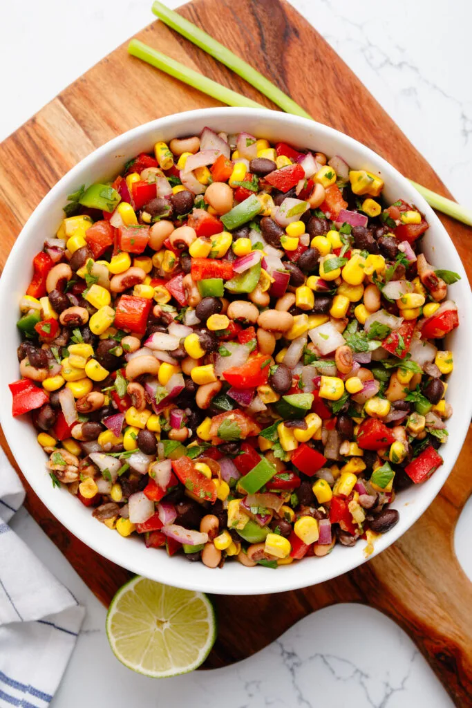 Cowboy caviar in a bowl on a wood cutting board