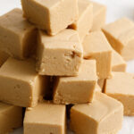Peanut butter fudge cut into squares and stacked on a counter