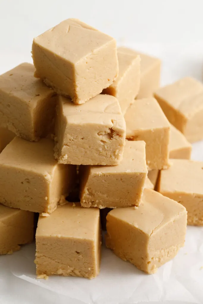 Peanut butter fudge cut into squares and stacked on a counter