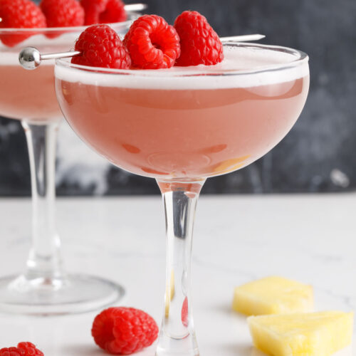French martinis on a counter with a raspberry garnish