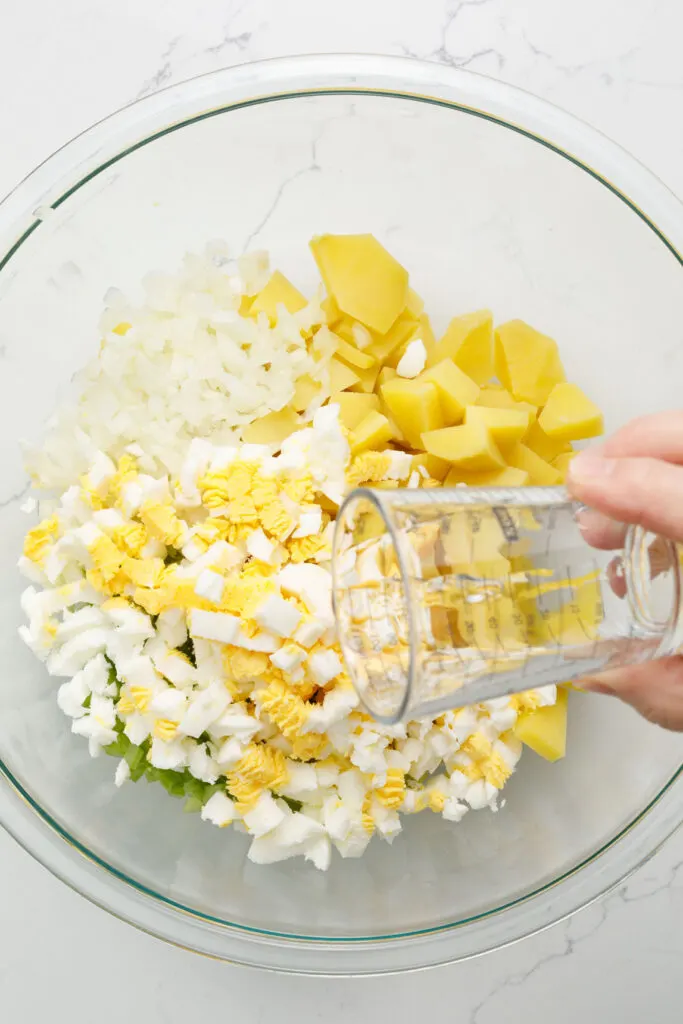 Pour vinegar over ingredients in the bowl