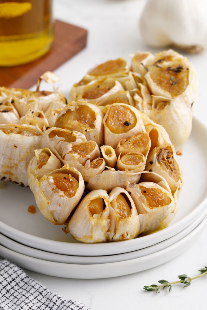 three garlic heads on a stack of plates
