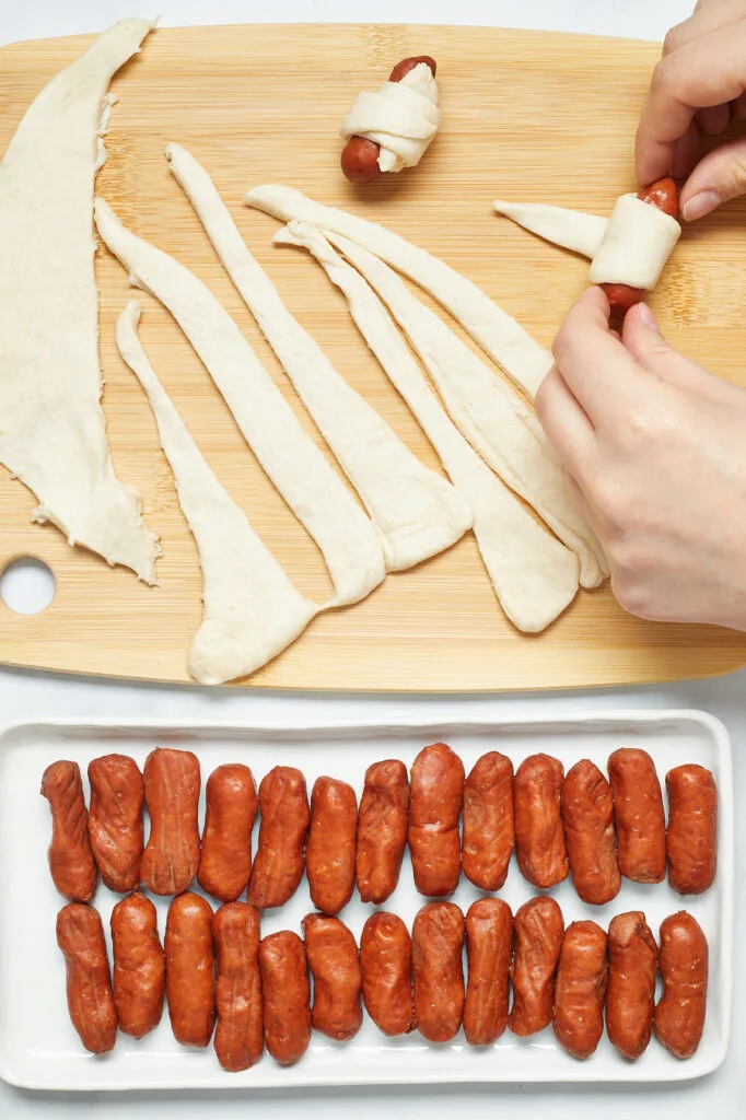 rolling crescent dough around little smokies