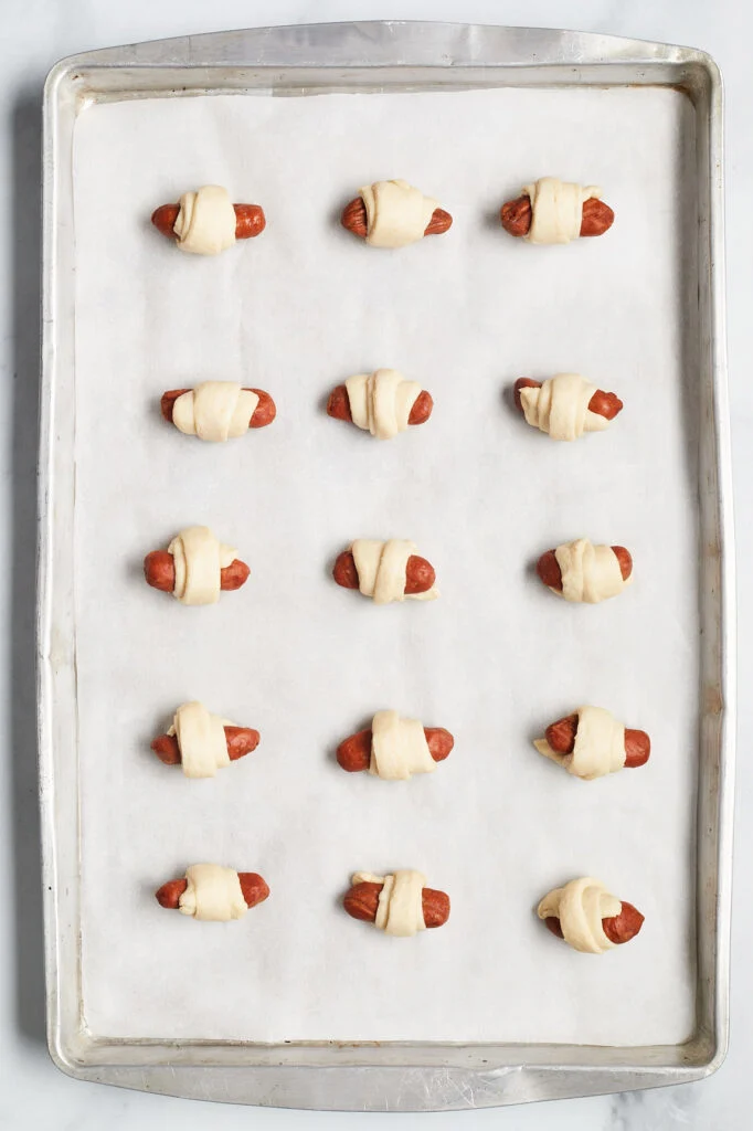 raw pigs in a blanket on a cookie sheet