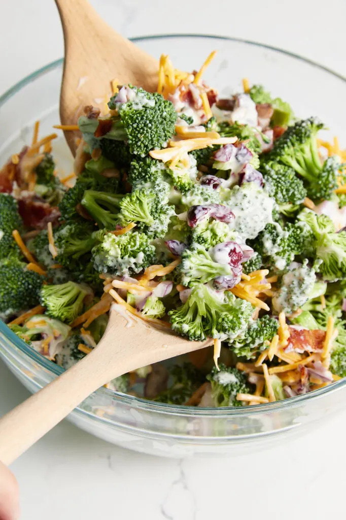 tossing the salad dressing into the broccoli mixture