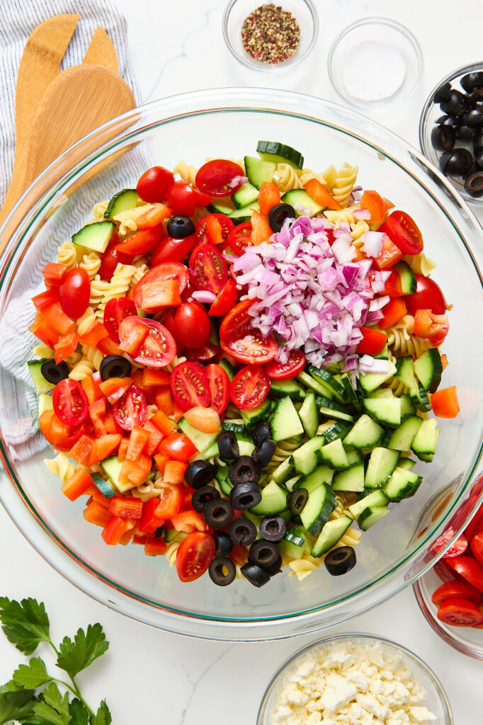 Salad vegetables and pasta in a mixing bowl